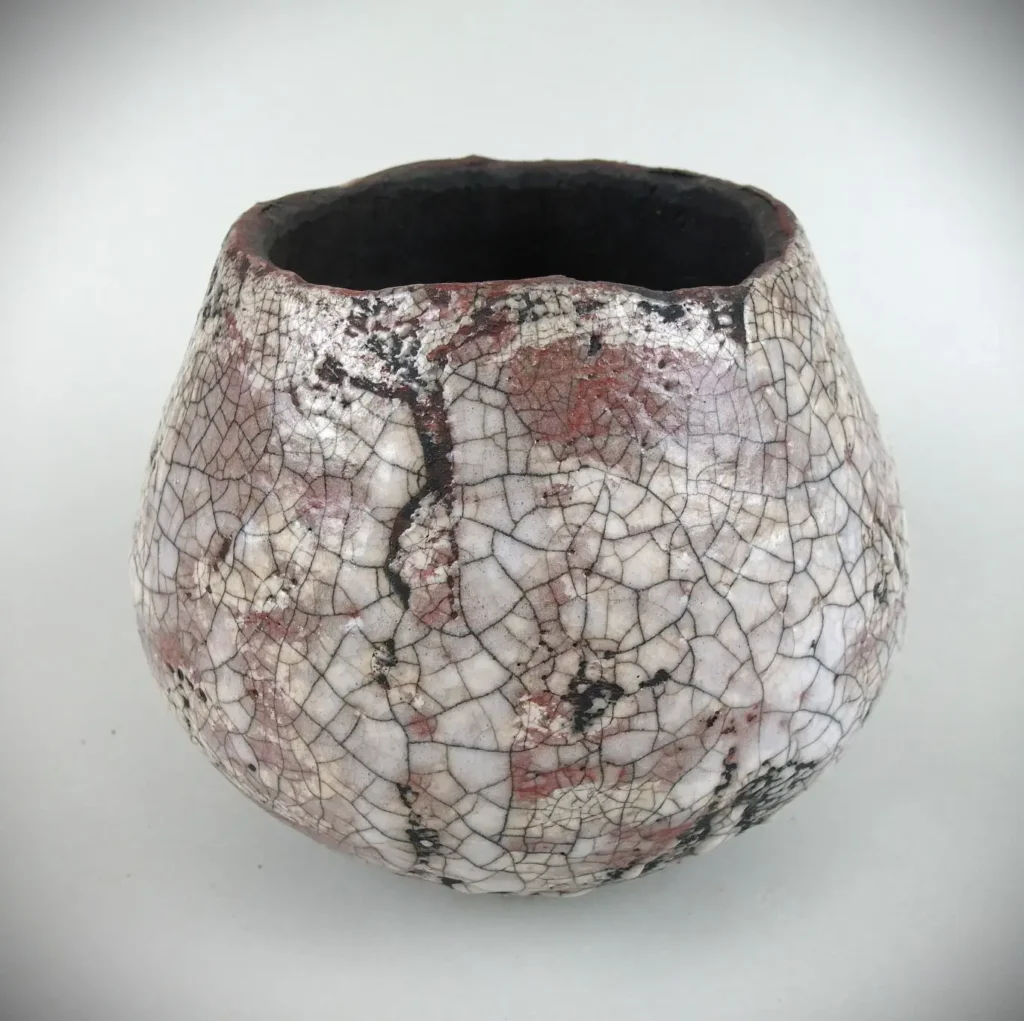 Gefäßobjekt in Wulsttechnik aus grob schamottierten Ton aufgebaut, glasiert, im Raku-Ofen gebrannt und Hobelspänen abgeräuchert.